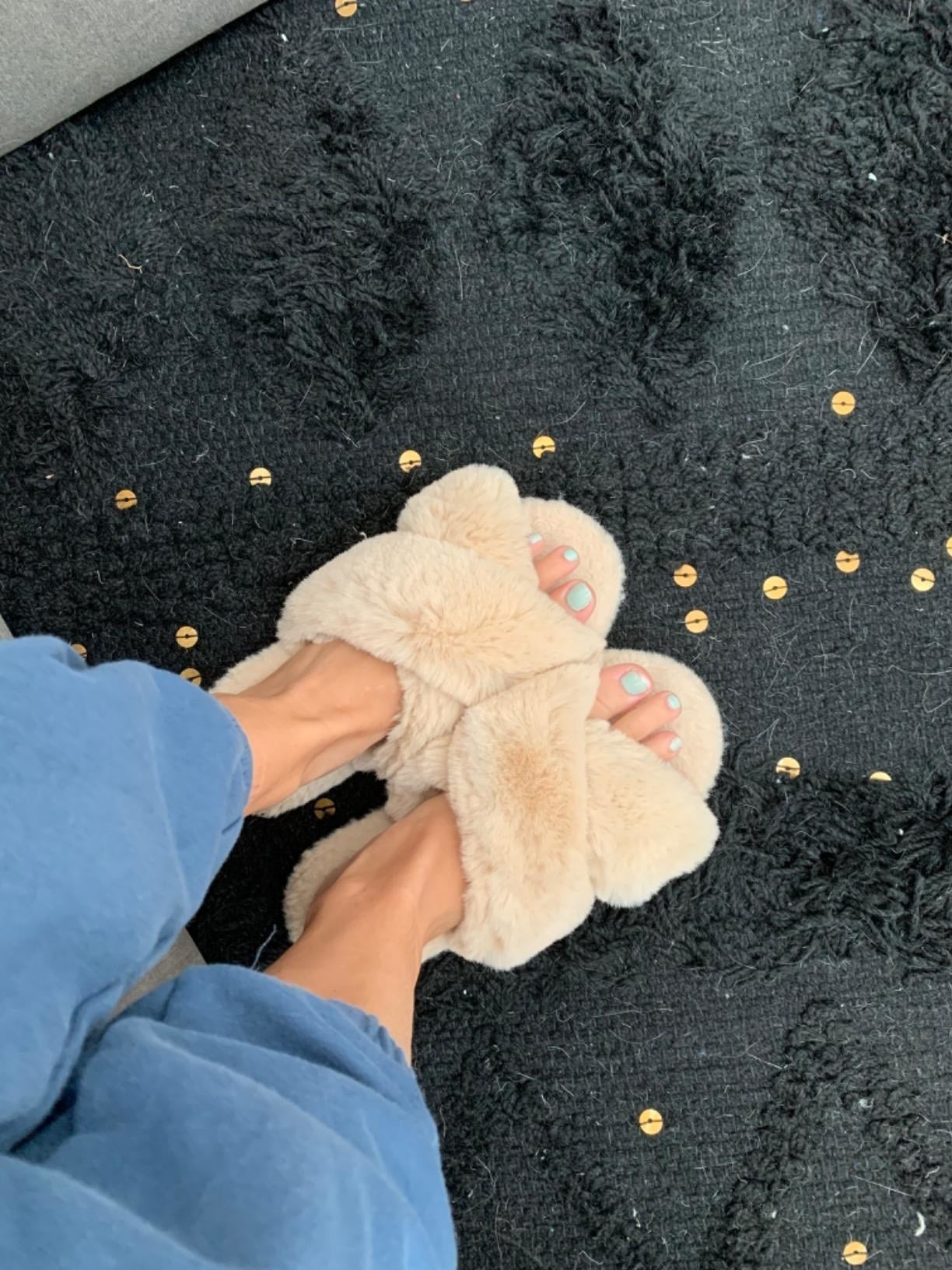 Beige cross-band fluffy slippers worn on feet